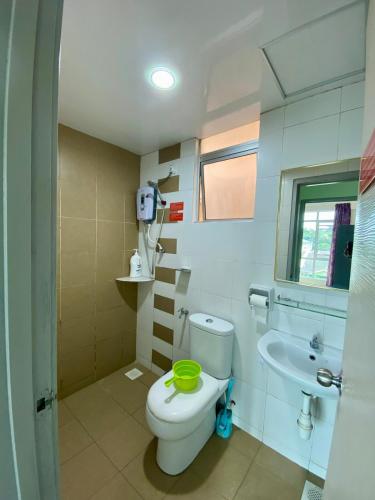 a bathroom with a toilet and a sink at SK Holiday Apartment in Tanah Rata