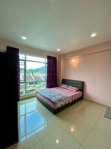a bedroom with a bed and a large window at SK Holiday Apartment in Tanah Rata