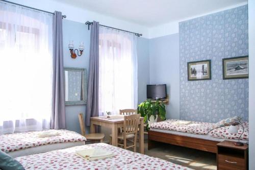 a bedroom with two beds and a table and a desk at Kajovska 64 in Český Krumlov