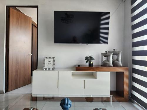a living room with a tv on a wall at Departamento nuevo y céntrico con ambiente familiar en Guadalajara in Guadalajara