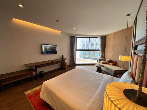 a hotel room with a bed and a piano at Apec Mandala Romantic Mui Ne in Ấp Thiẹn Ái