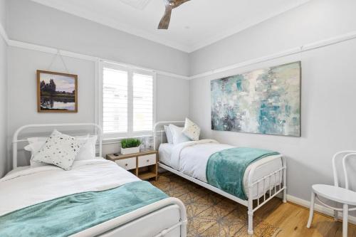 a bedroom with two beds and a table at Balmoral beauty - Elevated living on the esplanade BALO1 in Sydney