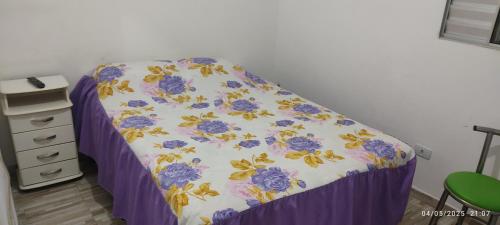 a bed in a room with a purple bed skirt at Ro&Dete aluguel de quartos de temporada em Taboão da Serra in Taboão da Serra