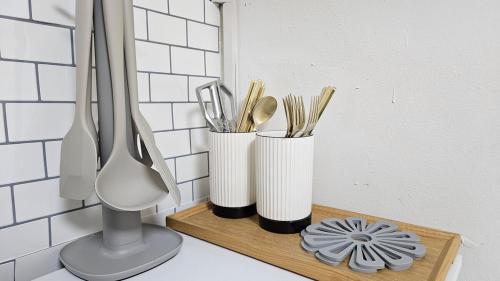 a counter with three cups and utensils on a shelf at Suwon Hwaseong 507, the happiest trip of my life Love Stay in Suwon