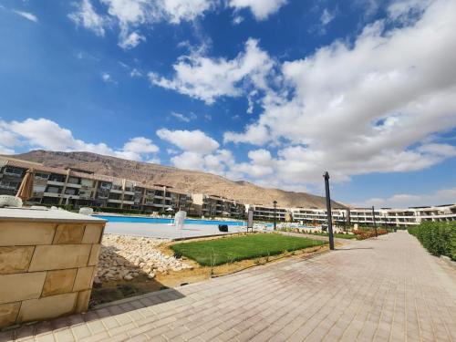 a large apartment building with a pool and a mountain at Peaceful Challette Two Bedrooms in Murano El Sokhna in Ain Sokhna