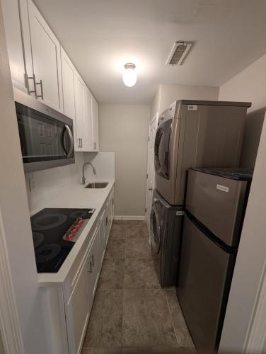 a small kitchen with a refrigerator and a sink at 2 Bedroom Basement Home in Conley