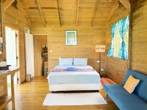 a bedroom with a bed and a blue couch at Tropical Villa, Private Lagoon in HUH