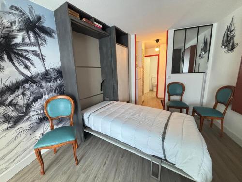 une chambre avec un lit et deux chaises dans l'établissement Studio accueillant pour 3, accès direct plage - FR-1-197-621, à Les Sables-dʼOlonne