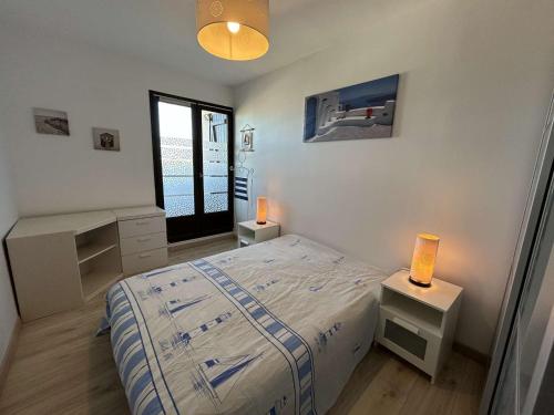 une chambre avec un lit et deux lampes et une fenêtre dans l'établissement Appartement moderne 3 pièces, vue mer, parking privé, 5 couchages - FR-1-224C-348, à Saint-Hilaire-de-Riez