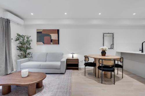 a living room with a couch and a table at Le Victoria Midtown Mtl in Montréal