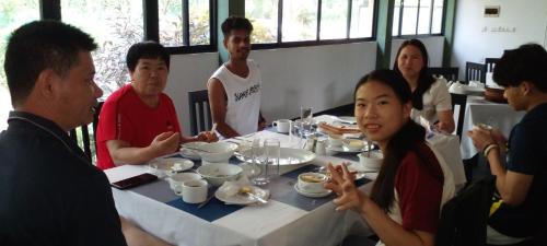a group of people sitting around a table eating food at Samudra Luxe Resort in Habarana