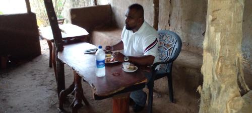 a man sitting at a table with a plate of food at Samudra Luxe Resort in Habarana