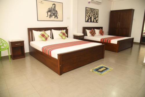 een slaapkamer met twee bedden in een kamer bij one love safari bungalow in Udawalawe