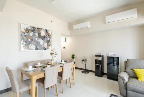 a living room with a table and chairs and a couch at Mystay25V-ParksuitesTower1 in Manila