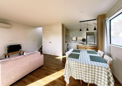 a living room with a table and a couch at Close to New Lynn train station 3 bedroom townhouse in Auckland