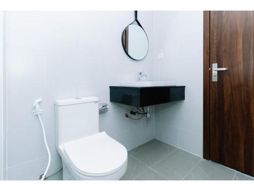 a bathroom with a white toilet and a sink at Fivitel Nam Hoi An Riverside in Thuận An