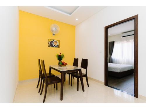a dining room with a table and chairs and a mirror at Fivitel Nam Hoi An Riverside in Thuận An