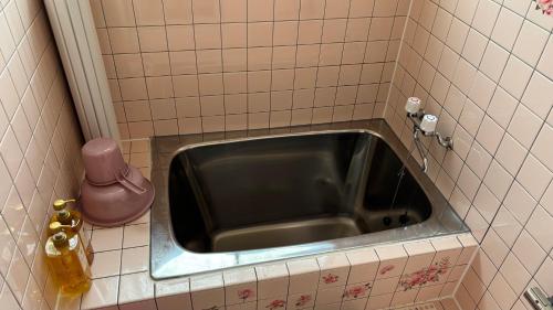 a metal sink in a tiled bathroom at SIBARIAN White House in Kaga