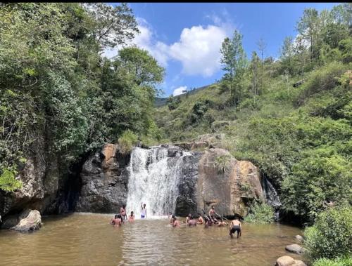 a group of people in the water near a waterfall at Sandy Luxury Villa 3 Bhk in Ooty