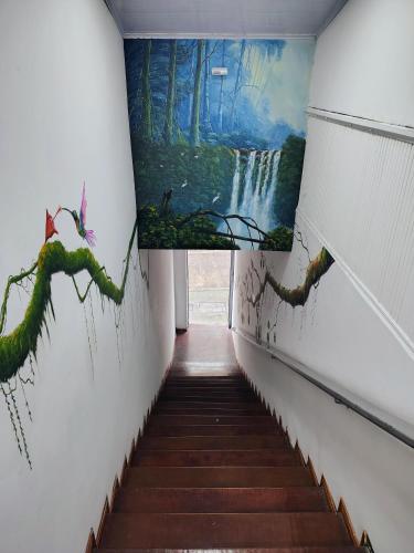 a hallway with paintings on the walls and stairs at Hotel Slow Montecarlo in Manizales