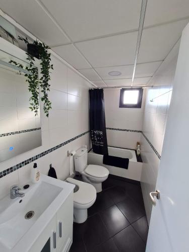 a white bathroom with a toilet and a sink at Attic terrace 360 Moncofa in Moncófar