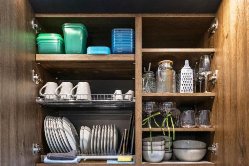 a cupboard filled with plates and bowls and dishes at Dune Suite - Palangos loftai in Palanga