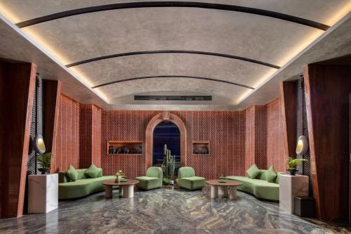 a lobby with green chairs and tables in a room at Mehao Lizhi Hotel Kashgar Donghu Park Branch in Kashgar