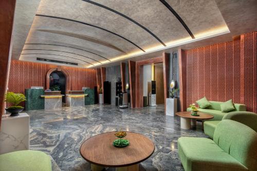 a lobby with green chairs and tables in a building at Mehao Lizhi Hotel Kashgar Donghu Park Branch in Kashgar