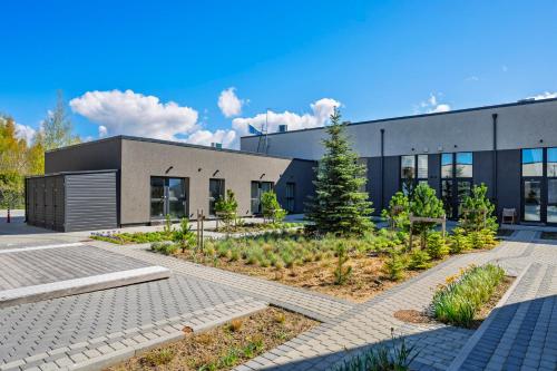 a building with a garden in front of it at Dune Suite - Palangos loftai in Palanga