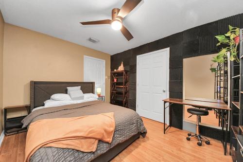 a bedroom with a bed and a desk and a ceiling fan at Ground Floor Suite fast WiFi&TV in Katy