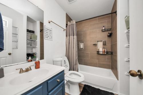 a bathroom with a toilet and a sink and a shower at Ground Floor Suite fast WiFi&TV in Katy