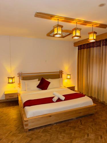 a bedroom with a large bed with two towels on it at Kesar Palace Hotel & Restaurant, Skardu in Skardu