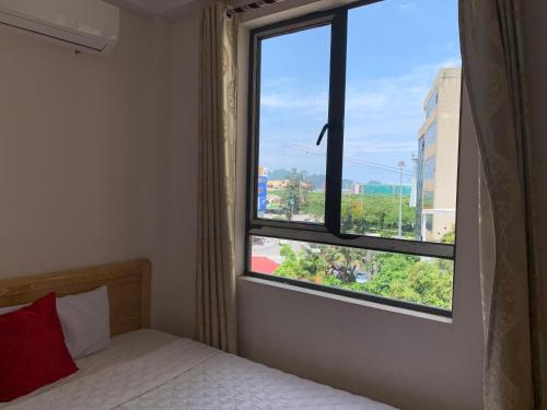 a bedroom with a bed and a large window at Quynh Yen Hotel in Ha Long