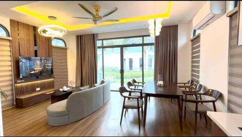 a living room with a couch and a table and chairs at Cozy Villa V3G08A in Sonasea - Vân Đồn - Gần biển- Đầy đủ tiện nghi in Thâm Câu