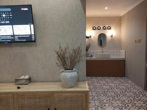 a vase sitting on a counter in a bathroom at Kenka Homestay in Jetis