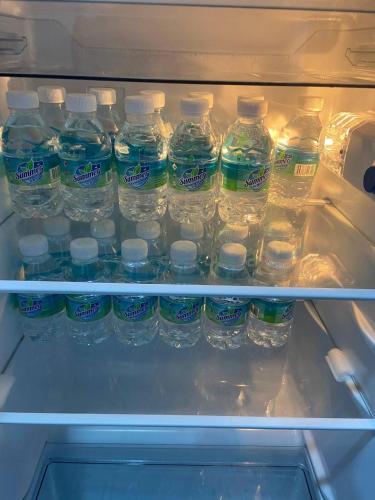 a refrigerator filled with lots of bottles of water at Homestay DNailah in Kampong Jelatang