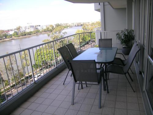 a balcony with a table and chairs and a view of a river at Fairthorpe Apartments in Brisbane