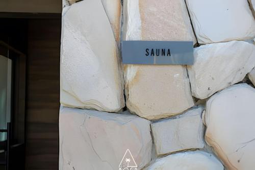 a stack of white rocks with a sign that reads sauna at Villa Naluri - Seu Refúgio a 50 metros da praia em Japaratinga in Japaratinga