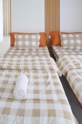 two beds sitting next to each other in a room at Dirumahjogja in Jarakan
