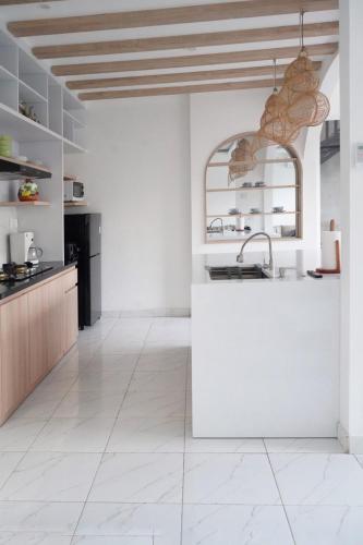 a kitchen with a white counter and a sink at Dirumahjogja in Jarakan