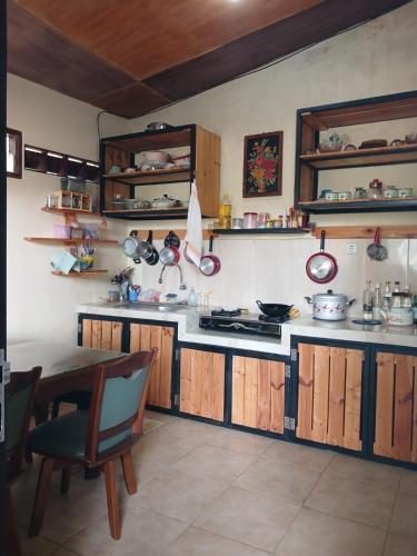 a kitchen with wooden cabinets and a table in it at Homestay Rumah Akung in Ngadipuro