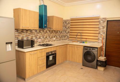 a kitchen with a washer and a dishwasher at Executive 2 Bedroom RealShala East Legon Hills in Maijaw