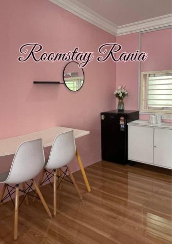 a room with a table and two chairs and a pink wall at AR HOMESTAY & ROOMESTAY in Merlimau