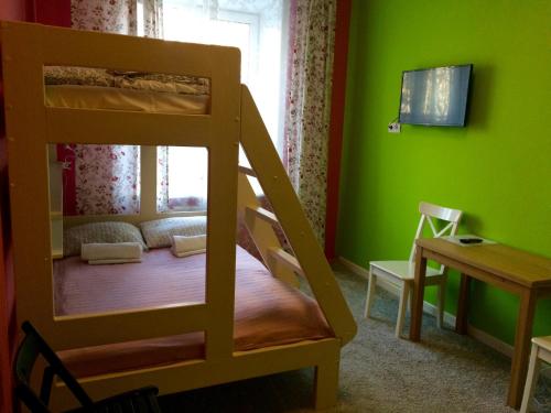 a room with a bunk bed and a table and a desk at Mini-Hotel Spi Zdes in Khabarovsk