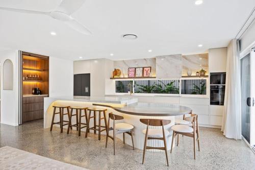 a kitchen with a table and stools in a room at Solis House in Tweed Heads