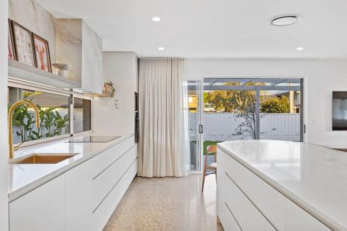 a white kitchen with a counter and a window at Solis House in Tweed Heads