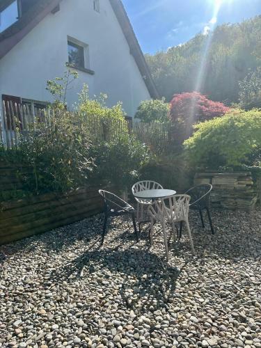 a patio with two chairs and a table in a garden at Moderne 65m2 Wohnung mit Garten am Waldrand nähe Basel in Rodersdorf