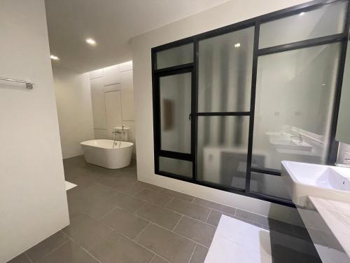 a bathroom with two sinks and a tub and a toilet at HOMETELhdy in Hat Yai