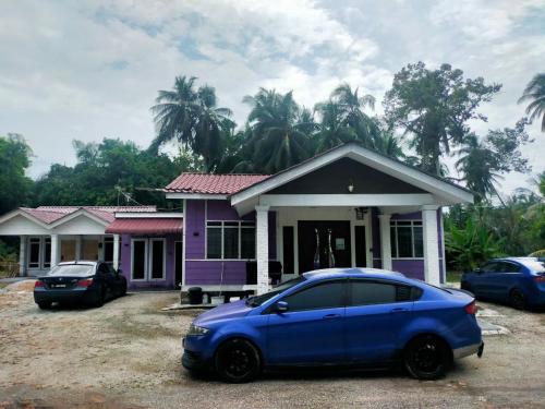 a blue car parked in front of a purple house at AR HOMESTAY & ROOMESTAY in Merlimau