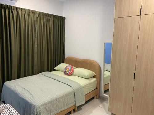 una piccola camera da letto con un letto e uno specchio di The Makciks Homestay Adelia2 a Kajang